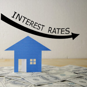 Interest of a fake house with an arrow pointing down that says interest rates