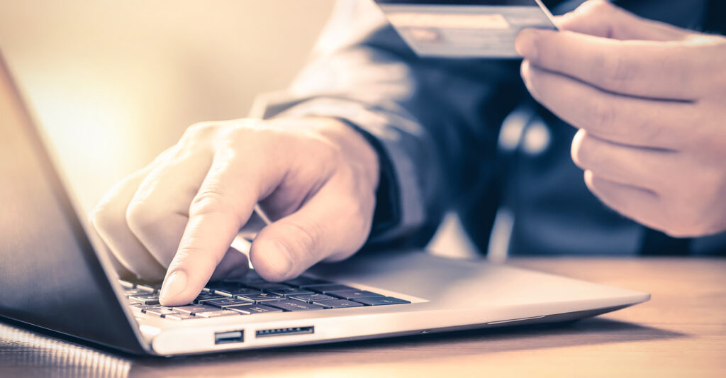 Image of a man with a credit card on his computer