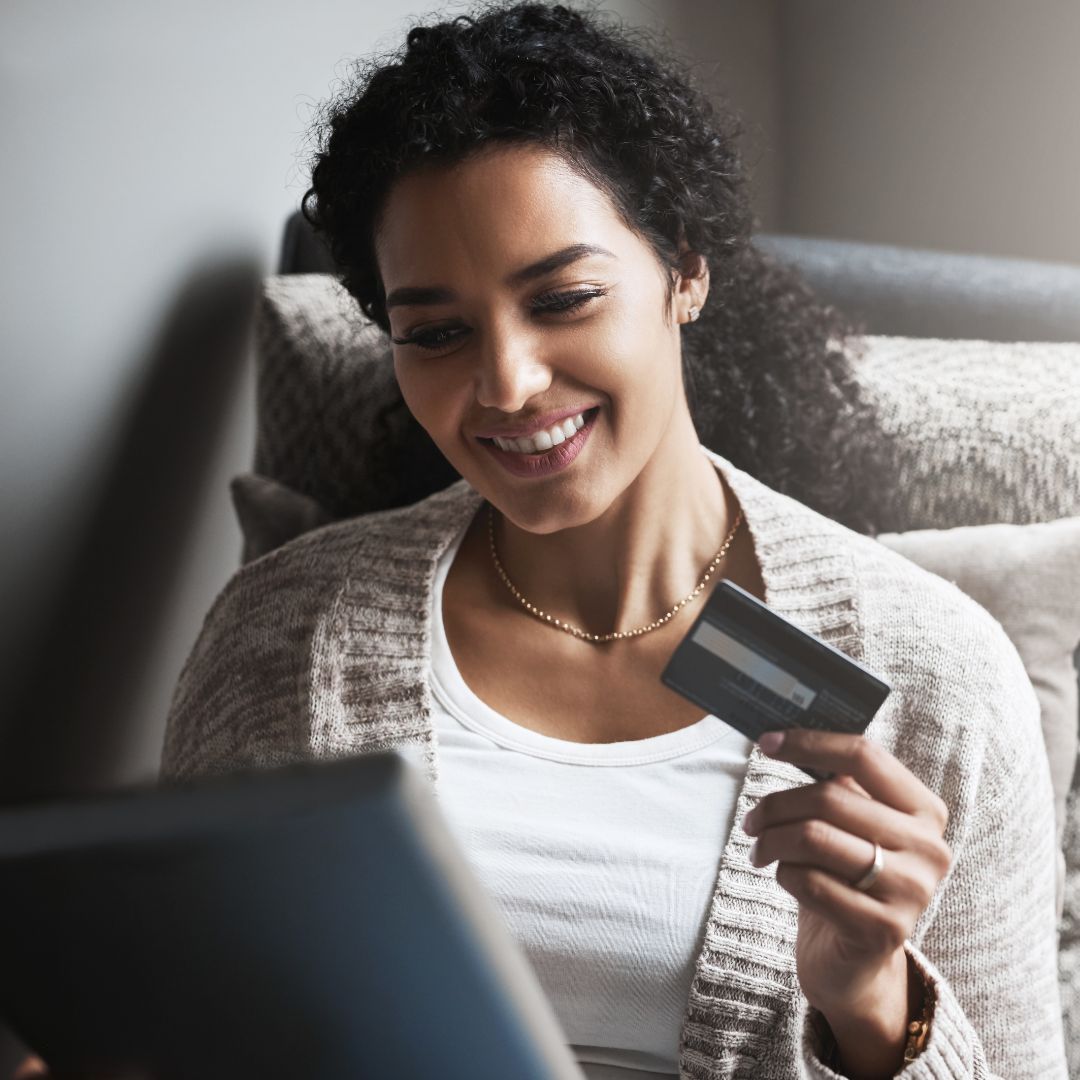 woman holding credit card on laptop
