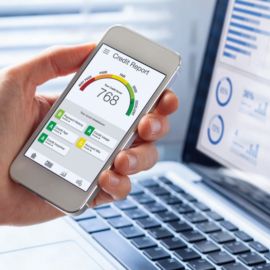 person checking credit score on phone laptop in the background