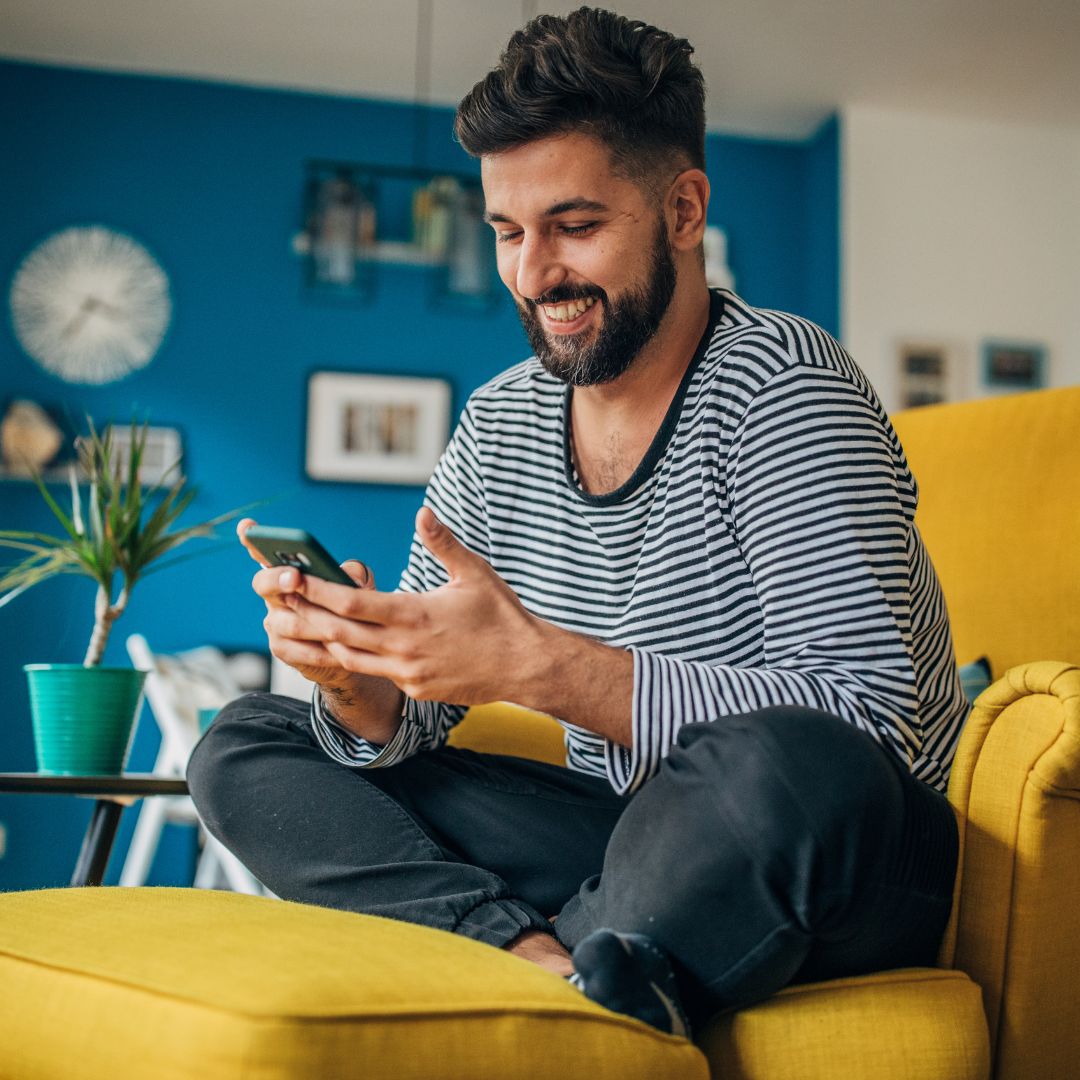 man scrolling on phone and smiling