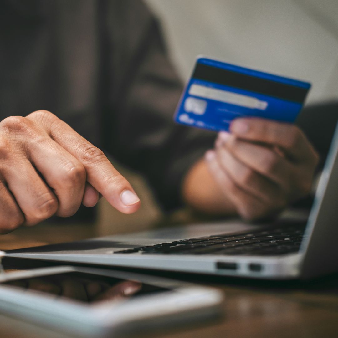 a person using a credit card on a laptop