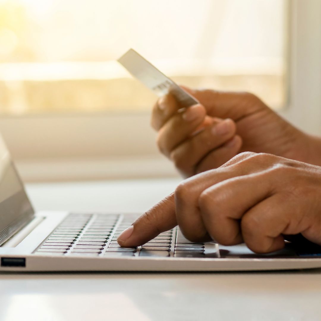 Person making payment on laptop with a credit card