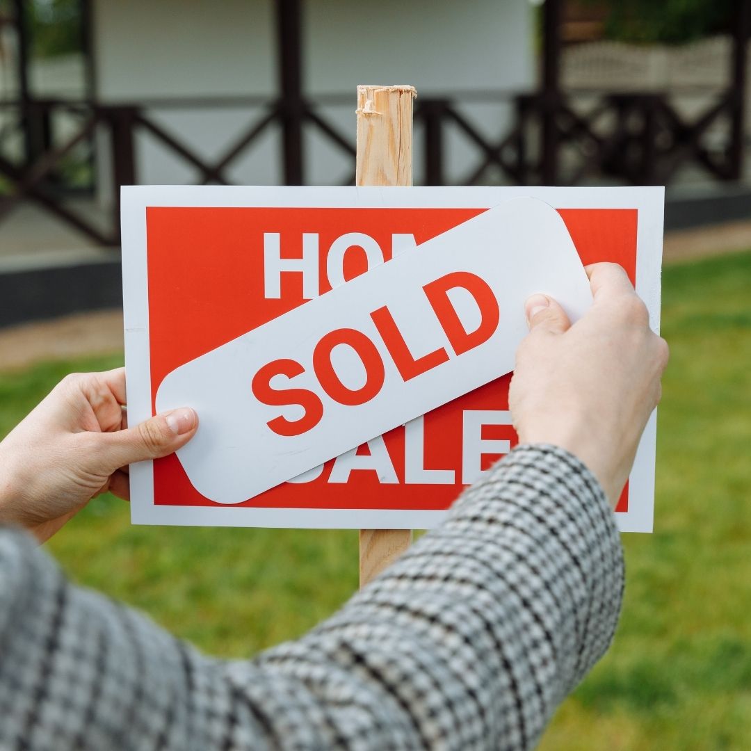 house for sale sign with a sold sticker